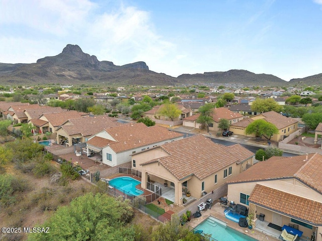 aerial view of residential area featuring a pool and a mountainous background