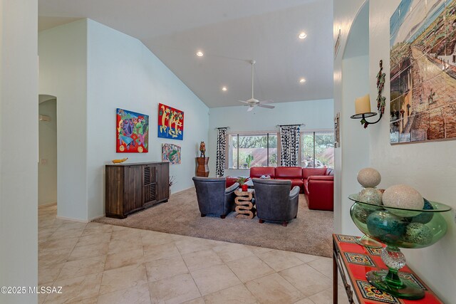 1328 N Mahogany Gulch Ln, Green Valley, AZ 85614 - living room with light carpet, ceiling fan, arched walkways, a glass covered fireplace, and high vaulted ceiling