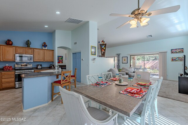 1328 N Mahogany Gulch Ln, Green Valley, AZ 85614 - kitchen with appliances with stainless steel finishes, vaulted ceiling, a kitchen breakfast bar, dark countertops, and light tile patterned floors