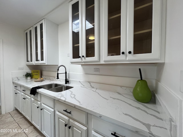 2838 E Beverly Dr, Tucson, AZ 85716 - kitchen featuring a sink, white cabinetry, light stone countertops, and glass insert cabinets