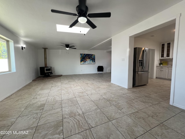2838 E Beverly Dr, Tucson, AZ 85716 - unfurnished living room featuring a wood stove and a ceiling fan