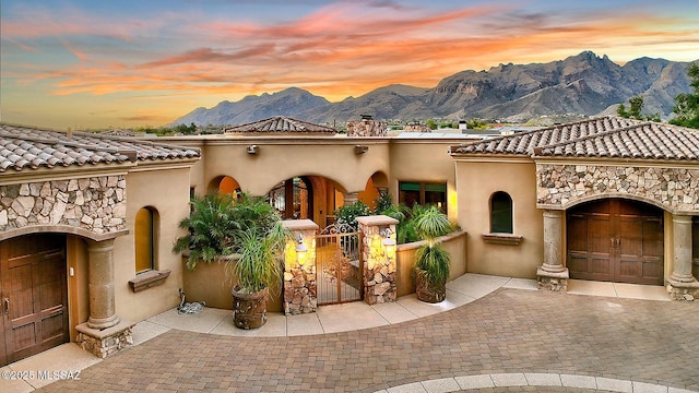 6015 N Camino Preciado, Tucson, AZ 85718 - view of front of house with a mountain view, curved driveway, stucco siding, a tile roof, and a chimney