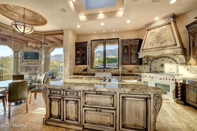 6015 N Camino Preciado, Tucson, AZ 85718 - kitchen with double oven range, stone tile flooring, a sink, recessed lighting, and light stone countertops