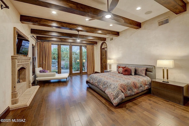 6015 N Camino Preciado, Tucson, AZ 85718 - bedroom featuring hardwood / wood-style floors, access to exterior, beamed ceiling, a fireplace with raised hearth, and recessed lighting