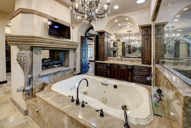 6015 N Camino Preciado, Tucson, AZ 85718 - full bathroom featuring a chandelier, a fireplace, a whirlpool tub, recessed lighting, and vanity