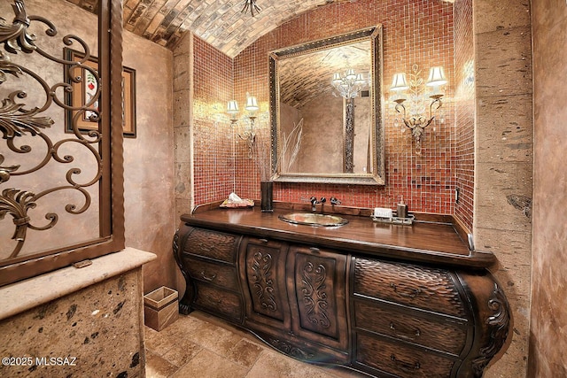 6015 N Camino Preciado, Tucson, AZ 85718 - bathroom with stone tile flooring, vaulted ceiling, brick ceiling, and vanity