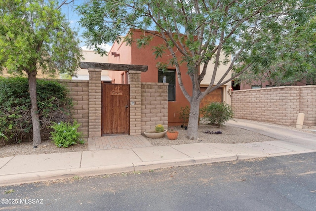 385 E Cedarvale Rd, Tucson, AZ 85704 - view of front of property featuring a fenced front yard, a gate, and stucco siding