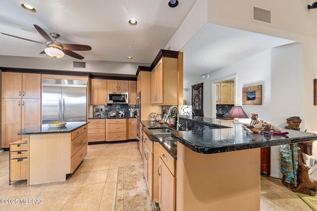 kitchen with stainless steel appliances, a sink, a ceiling fan, tasteful backsplash, and light tile patterned flooring