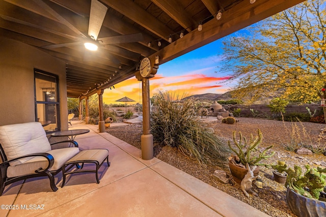 patio terrace at dusk featuring fence
