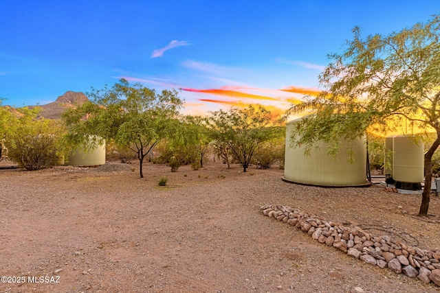 yard at dusk with an outdoor structure and a shed