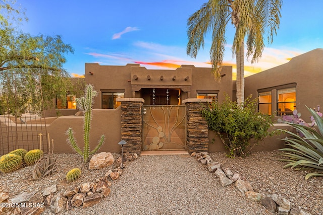 pueblo-style house with stucco siding