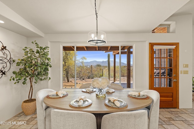 6891 N Camino Verde, Tucson, AZ 85743 - dining room with plenty of natural light, a notable chandelier, a mountain view, and stone tile flooring