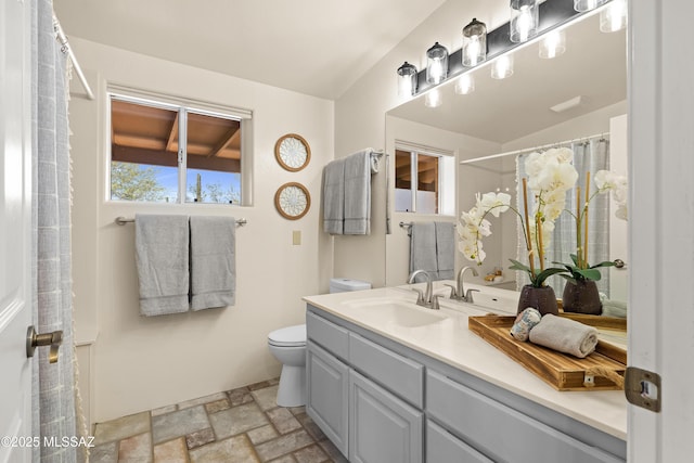 6891 N Camino Verde, Tucson, AZ 85743 - bathroom with toilet, vanity, and stone finish floor