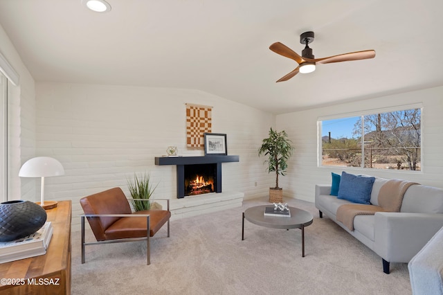6891 N Camino Verde, Tucson, AZ 85743 - carpeted living area featuring a ceiling fan, a lit fireplace, and vaulted ceiling