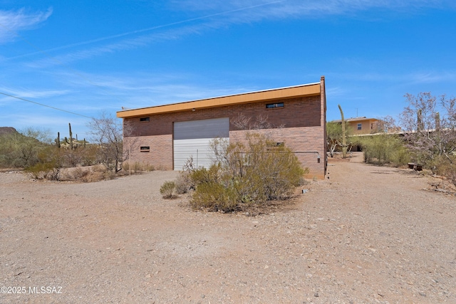 6891 N Camino Verde, Tucson, AZ 85743 - exterior space featuring a chimney, driveway, an outdoor structure, and brick siding