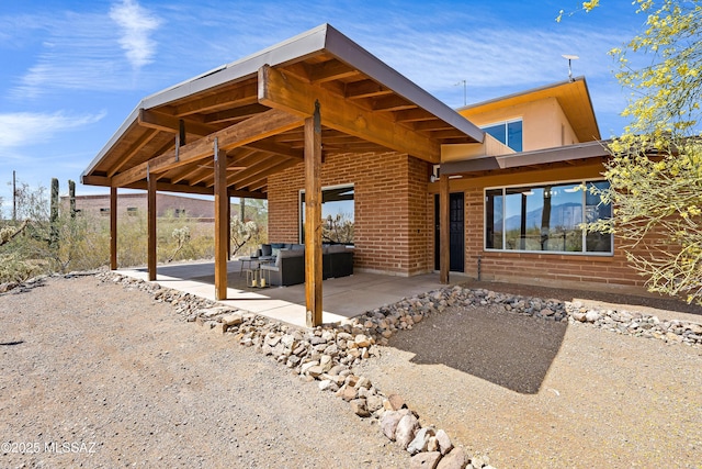 6891 N Camino Verde, Tucson, AZ 85743 - back of house with an outdoor hangout area, a patio area, and brick siding