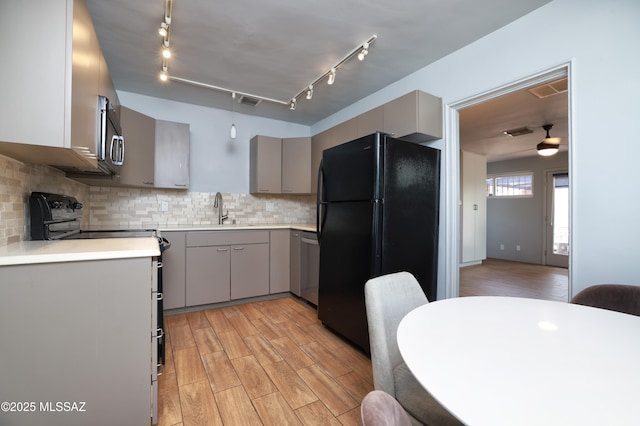 1700 E Water St, Tucson, AZ 85719 - kitchen with stainless steel appliances, gray cabinets, a sink, light countertops, and tasteful backsplash
