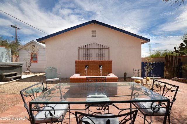 1700 E Water St, Tucson, AZ 85719 - view of patio / terrace with a hot tub, outdoor dining area, and fence