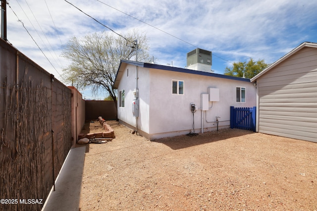 1700 E Water St, Tucson, AZ 85719 - back of house with a fenced backyard, a chimney, stucco siding, and central AC unit