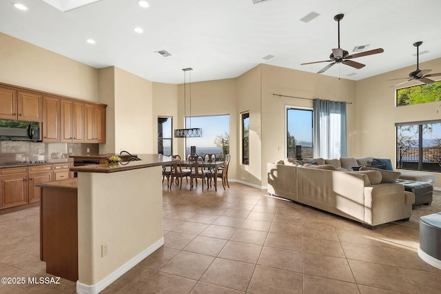 17950 S Via El Caballo Prieto, Vail, AZ 85641 - kitchen with black microwave, open floor plan, dark countertops, light tile patterned floors, and recessed lighting