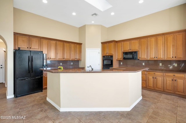 17950 S Via El Caballo Prieto, Vail, AZ 85641 - kitchen with black appliances, a towering ceiling, a spacious island, arched walkways, and a skylight