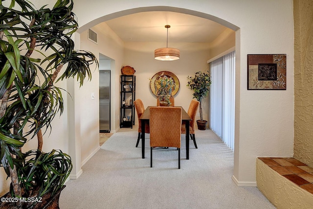 4640 E Via Pimeria Alta, Tucson, AZ 85718 - dining room featuring light carpet, arched walkways, and a textured wall