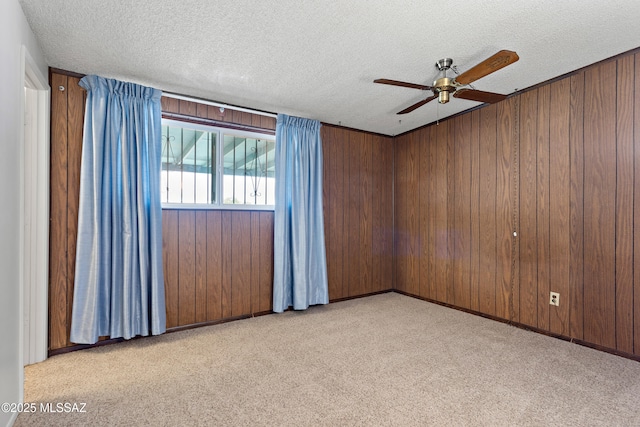 7634 E Apple Tree Dr, Tucson, AZ 85730 - empty room with ceiling fan, a textured ceiling, light carpet, and wooden walls