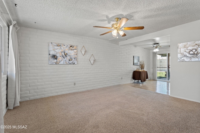 7634 E Apple Tree Dr, Tucson, AZ 85730 - carpeted spare room featuring brick wall, a ceiling fan, and a textured ceiling