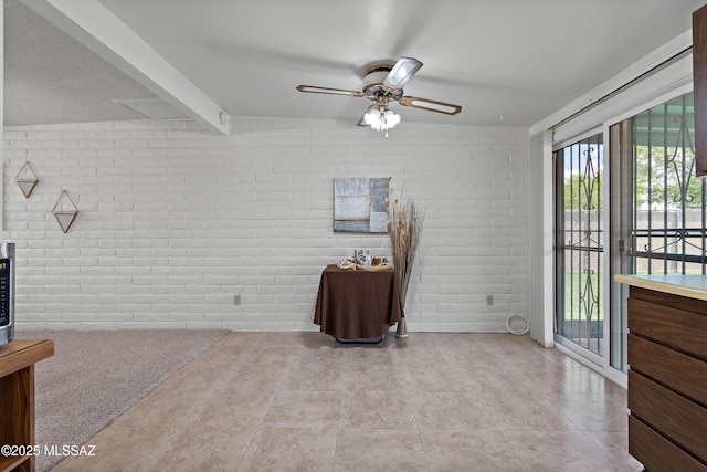 7634 E Apple Tree Dr, Tucson, AZ 85730 - unfurnished room with brick wall, a ceiling fan, and beamed ceiling