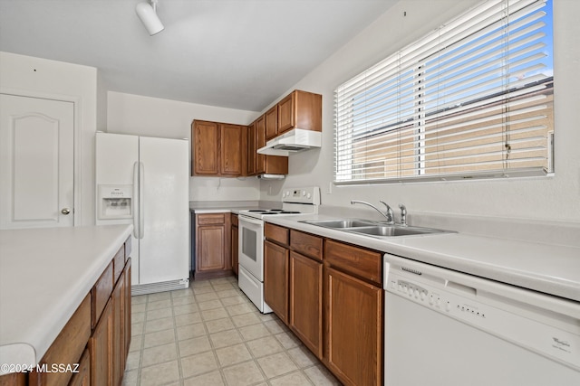 9410 E Grapevine Spring Pl, Tucson, AZ 85710 - kitchen with brown cabinetry, white appliances, light countertops, and a sink