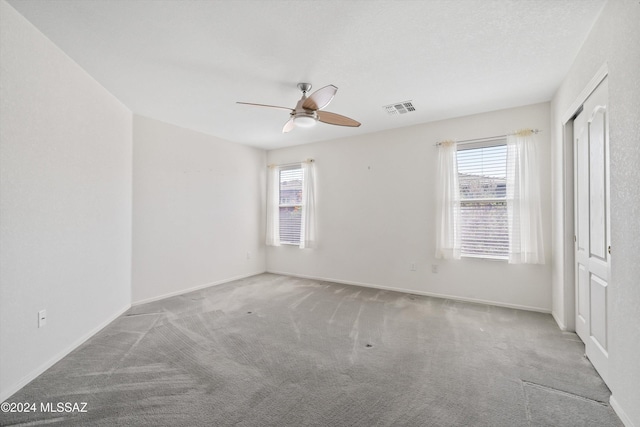 9410 E Grapevine Spring Pl, Tucson, AZ 85710 - carpeted spare room with plenty of natural light, baseboards, a ceiling fan, and visible vents