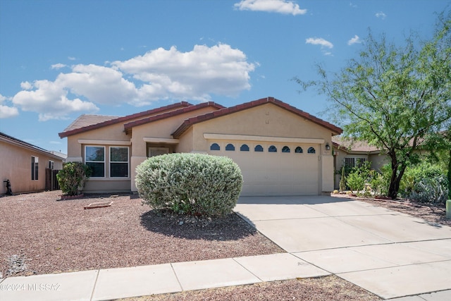 9410 E Grapevine Spring Pl, Tucson, AZ 85710 - view of front of home with an attached garage, concrete driveway, stucco siding, and a tile roof