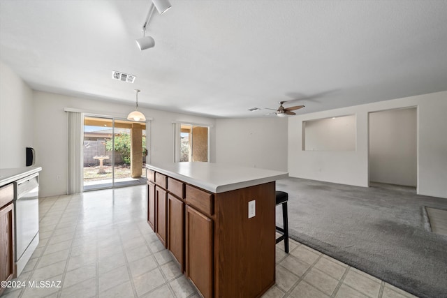 9410 E Grapevine Spring Pl, Tucson, AZ 85710 - kitchen featuring light countertops, a ceiling fan, a kitchen bar, visible vents, and dishwasher