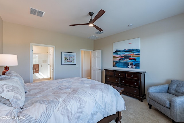 bedroom with light colored carpet, ceiling fan, and ensuite bath