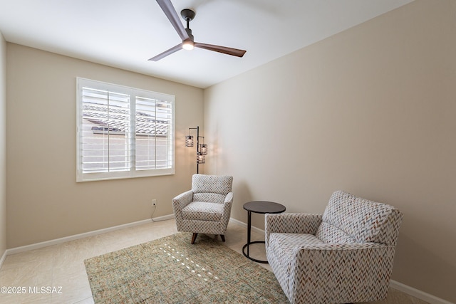 sitting room with a ceiling fan and baseboards