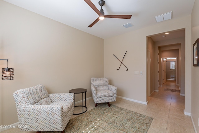 sitting room with a ceiling fan and baseboards