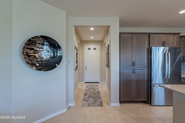 kitchen with freestanding refrigerator, dark brown cabinetry, baseboards, recessed lighting, and light countertops