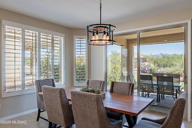 dining space featuring a chandelier and baseboards