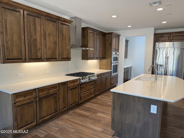 61662 E Quartzite Rd, Oracle, AZ 85623 - kitchen with wall chimney exhaust hood, appliances with stainless steel finishes, a sink, dark wood-style floors, and light countertops