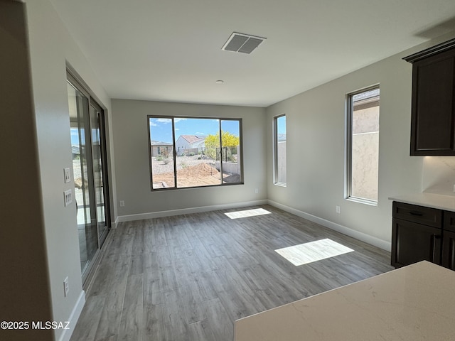 61662 E Quartzite Rd, Oracle, AZ 85623 - unfurnished dining area featuring light wood-style floors and baseboards