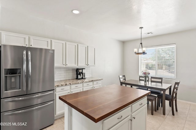 5523 W Carriage Dr, Tucson, AZ 85742 - kitchen featuring stainless steel refrigerator with ice dispenser, butcher block countertops, light tile patterned floors, white cabinetry, and recessed lighting