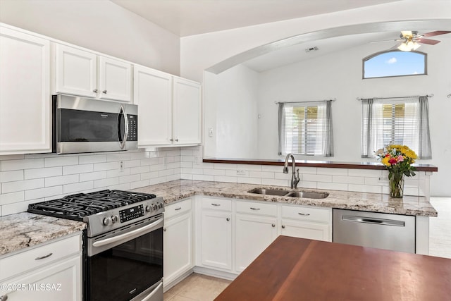 5523 W Carriage Dr, Tucson, AZ 85742 - kitchen with stainless steel appliances, a sink, a ceiling fan, white cabinetry, and vaulted ceiling