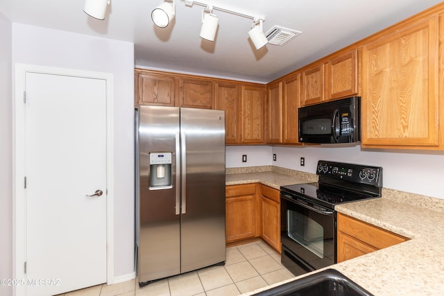 6591 S Avenida Santa Carolina, Tucson, AZ 85756 - kitchen featuring black appliances, light countertops, light tile patterned floors, and brown cabinetry