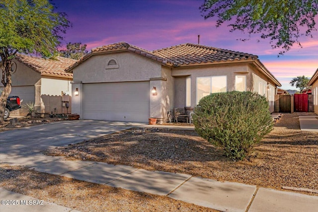7497 W Mission View Pl, Tucson, AZ 85743 - mediterranean / spanish-style house featuring stucco siding, an attached garage, driveway, and a tile roof