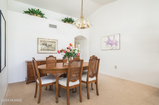 14670 N Wonderview Dr, Oro Valley, AZ 85755 - dining area with arched walkways, a chandelier, light carpet, lofted ceiling, and baseboards