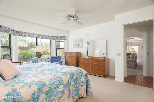 14670 N Wonderview Dr, Oro Valley, AZ 85755 - bedroom with light colored carpet, arched walkways, a ceiling fan, and baseboards