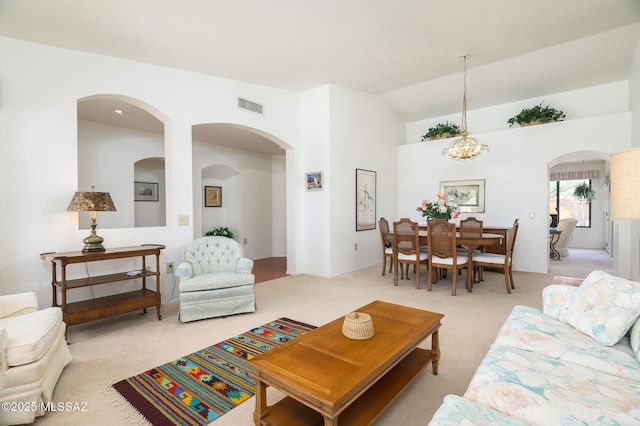14670 N Wonderview Dr, Oro Valley, AZ 85755 - living area with light carpet, arched walkways, a chandelier, and high vaulted ceiling