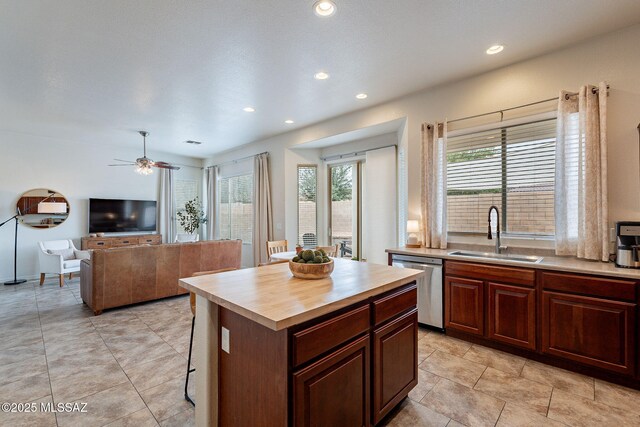 kitchen featuring a sink, stainless steel dishwasher, recessed lighting, ceiling fan, and a kitchen island