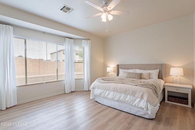 bedroom featuring wood finished floors, baseboards, and ceiling fan