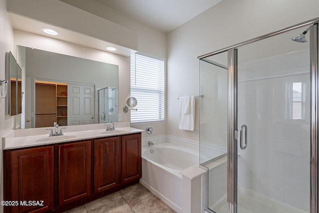 full bath with a stall shower, a garden tub, tile patterned flooring, and double vanity